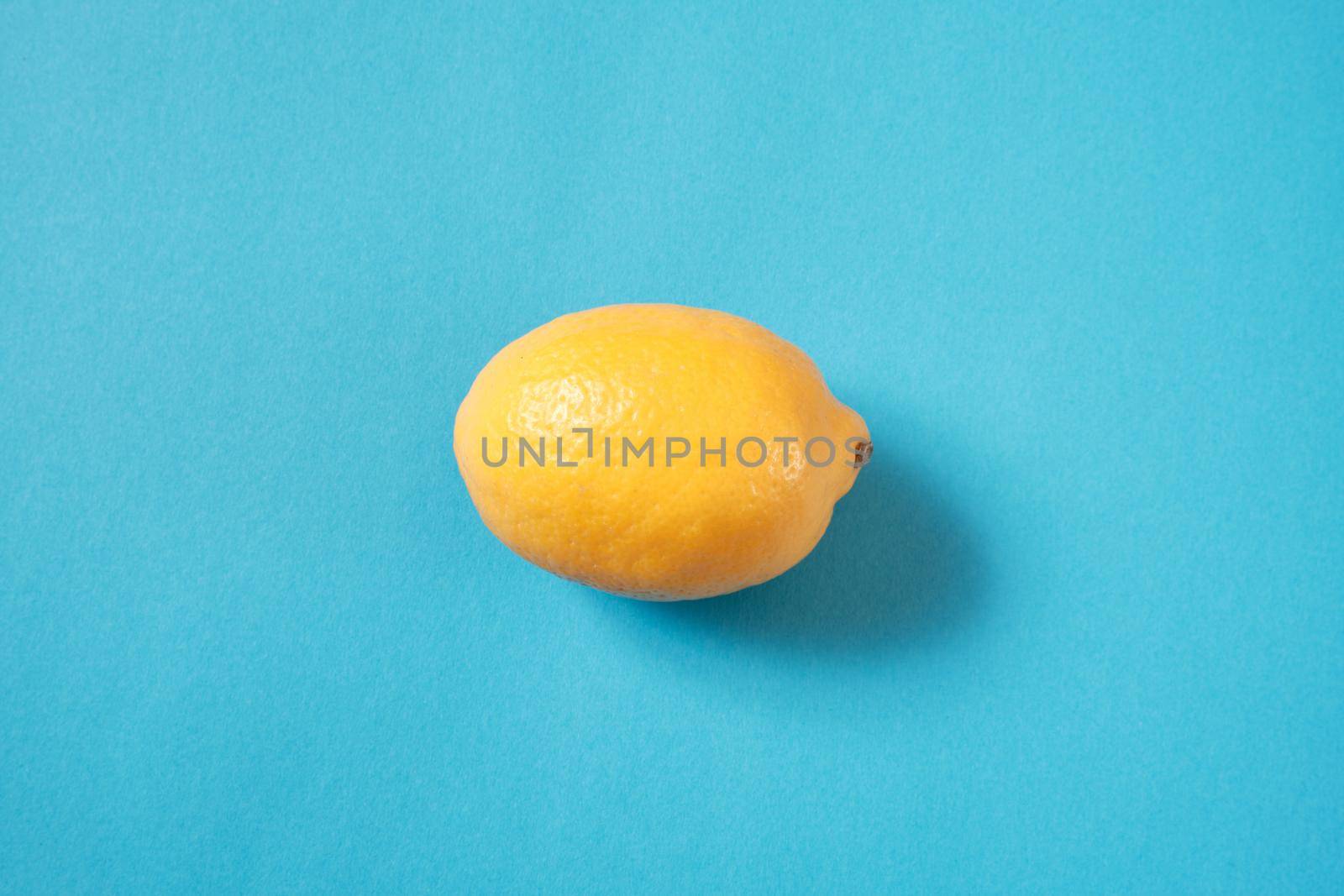 Fresh lemon lies on a blue textured background