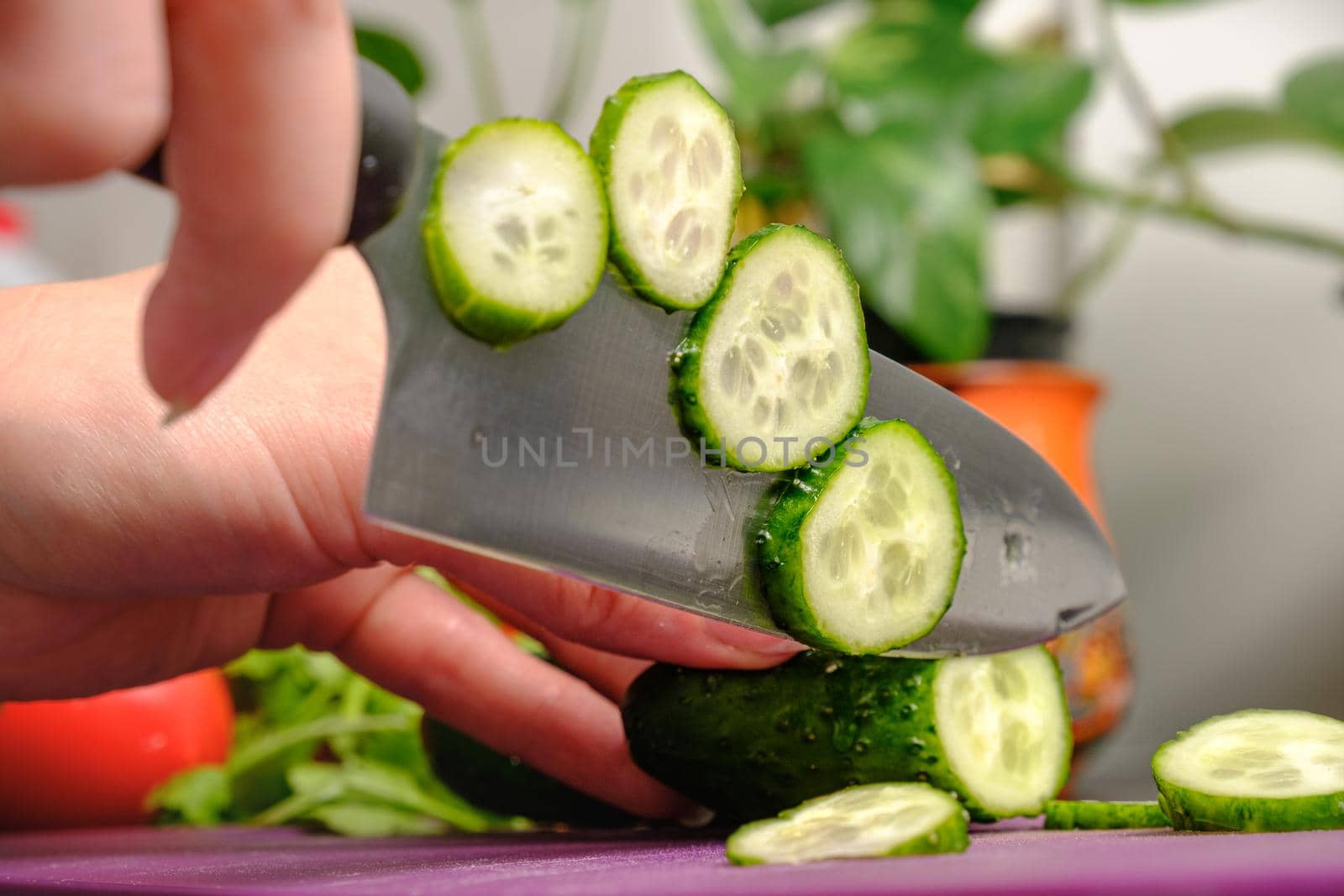 Slicing cucumbers with a knife on a cutting board