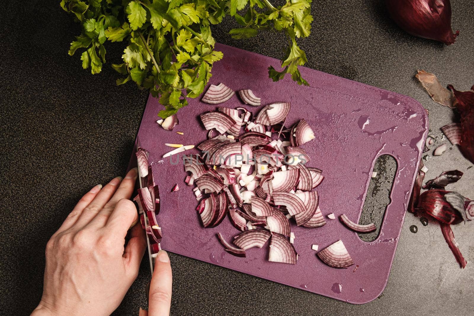 Slicing onions with a knife on a cutting board