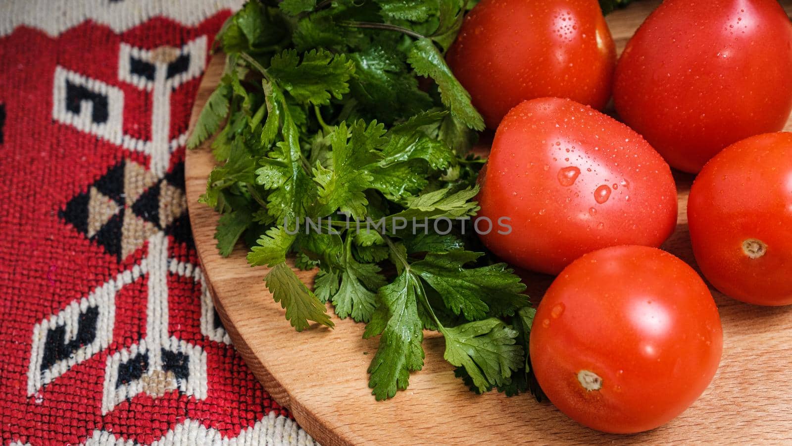 Tomatoes, cucumbers and herbs on a cutting board
