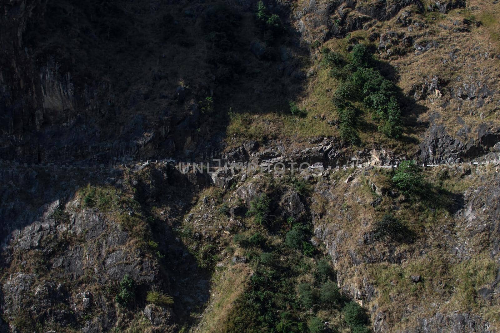 Two cars driving close to a steep edge on the road to Manang, Annapurna circuit, Nepal