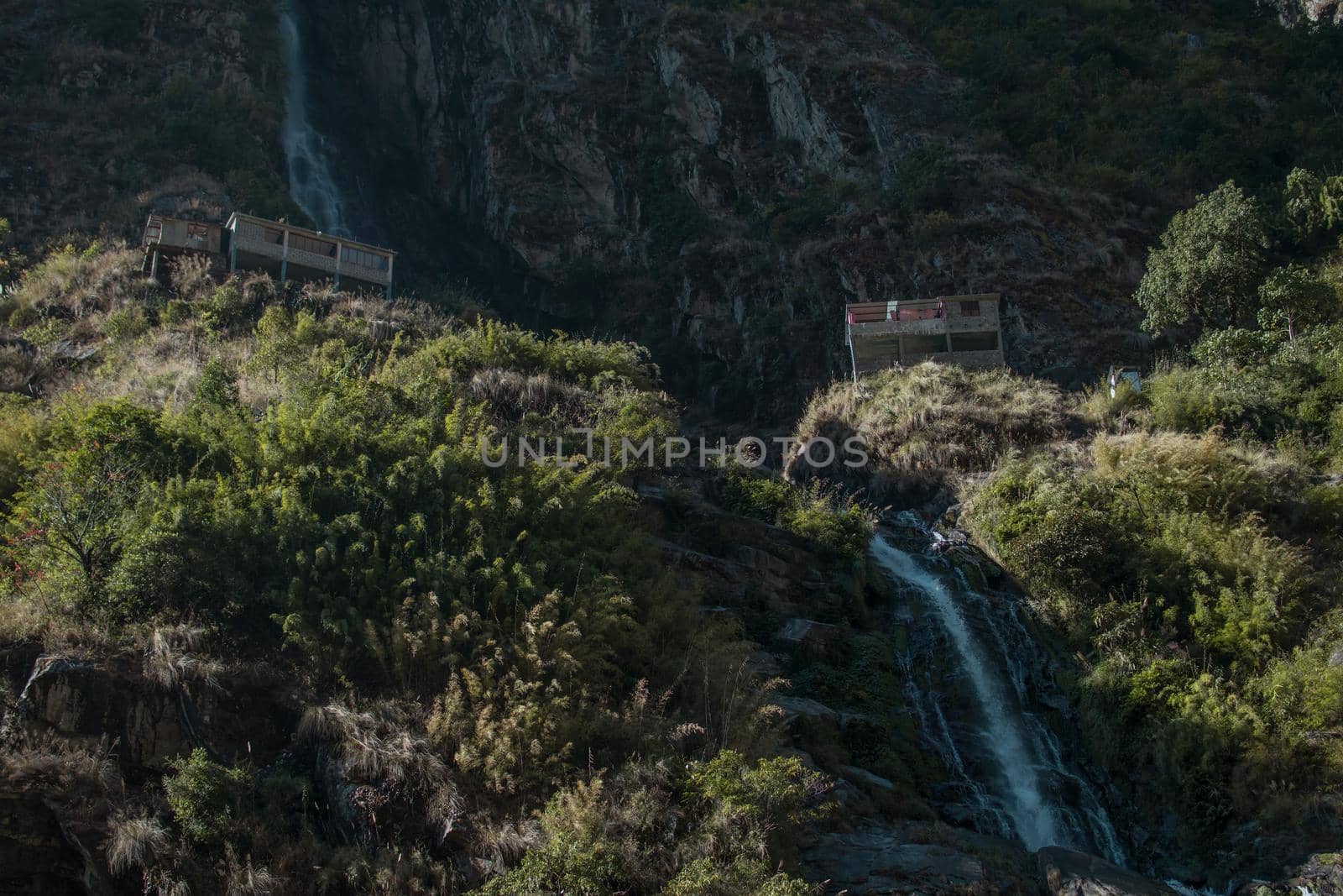 Waterfall flowing between two tea houses, into Marshyangdi river, Annapurna circuit, Nepal