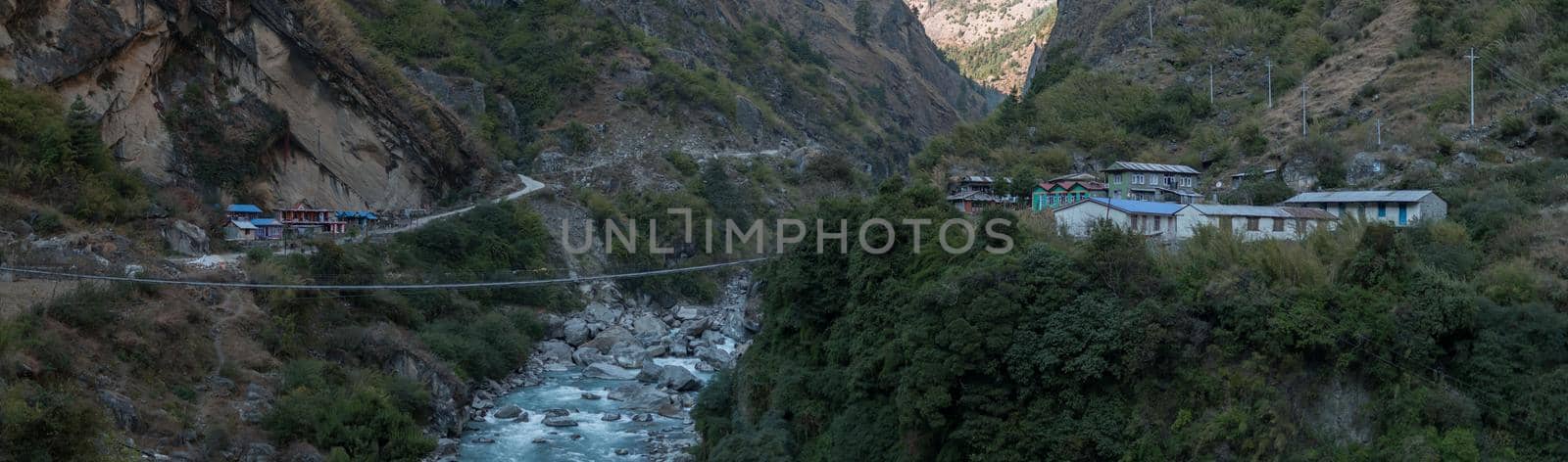 Panorama of nepalese mountain village by a suspension bridge over the Marshyangdi river gorge valley, Annapurna circuit, Himalaya, Nepal, Asia