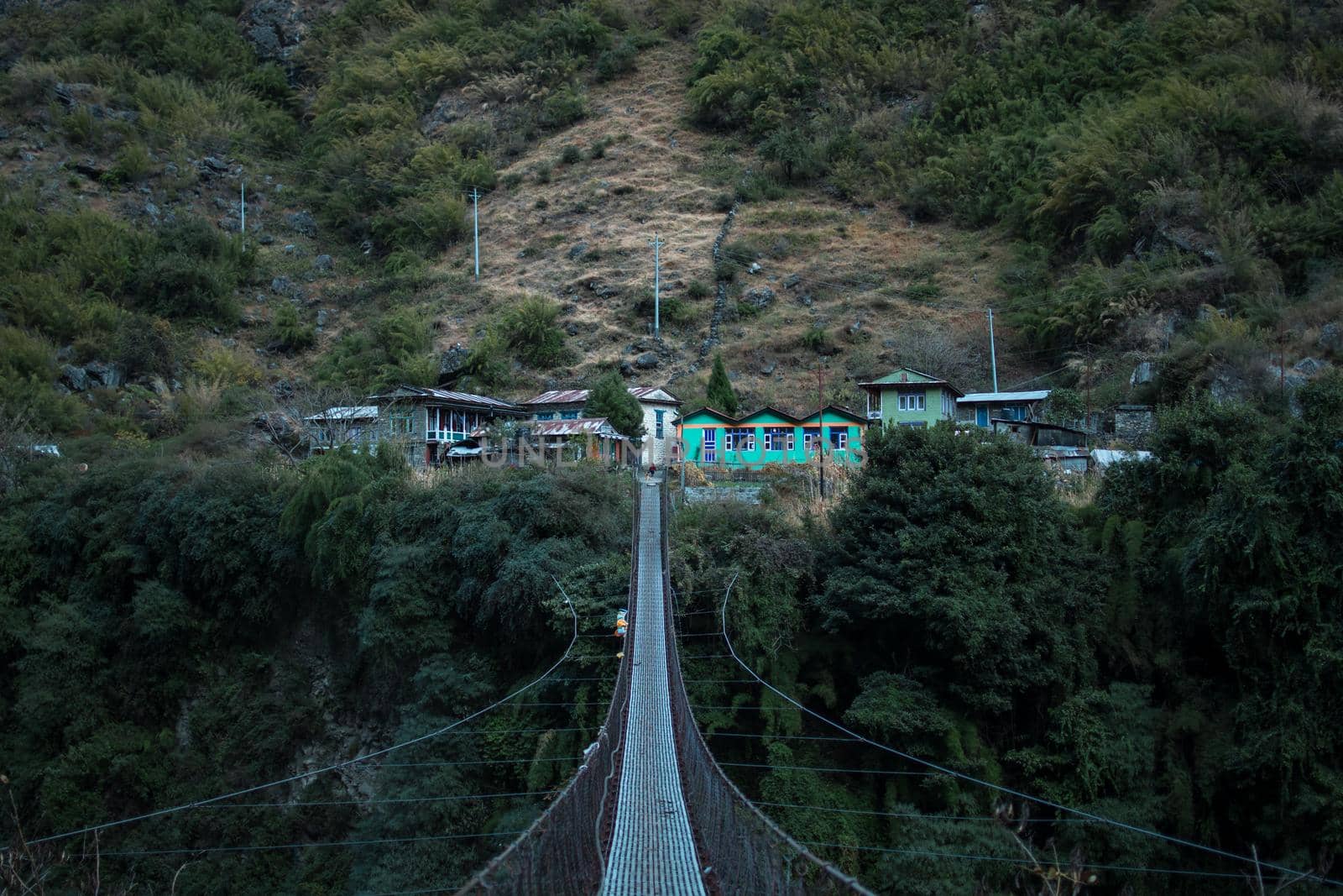 Nepalese mountain village by a suspension bridge over the Marshyangdi river gorge valley, Annapurna circuit, Himalaya, Nepal, Asia