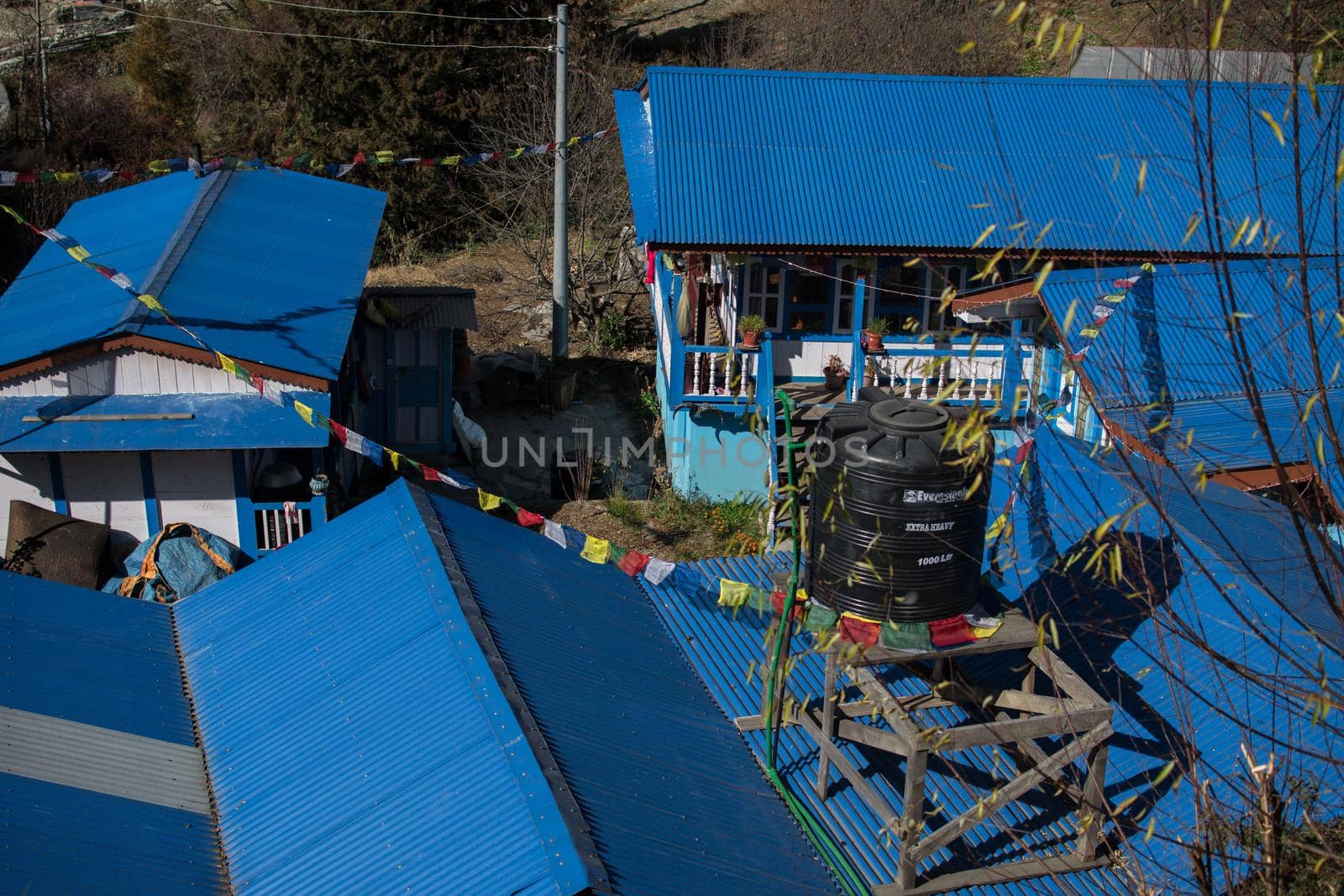 Blue tea houses with buddhist prayer flags in nepalese mountain village