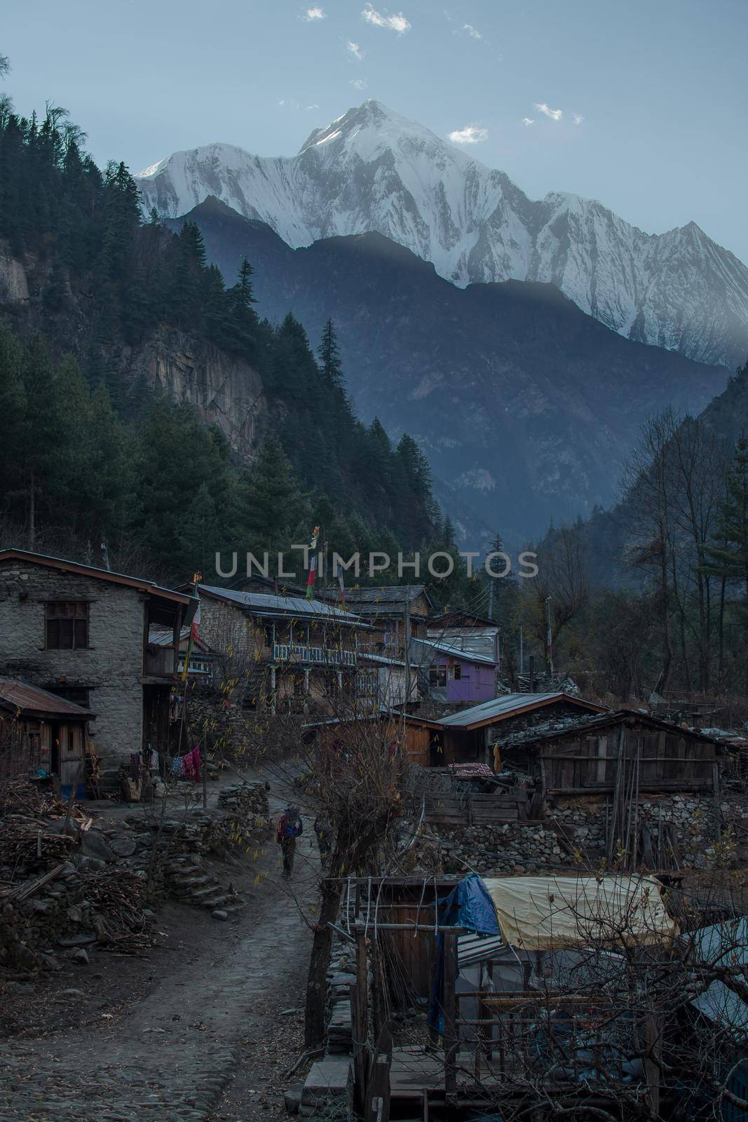 Two hikers trekking through nepalese mountain village, Annapurna circuit, Himalaya, Nepal, Asia