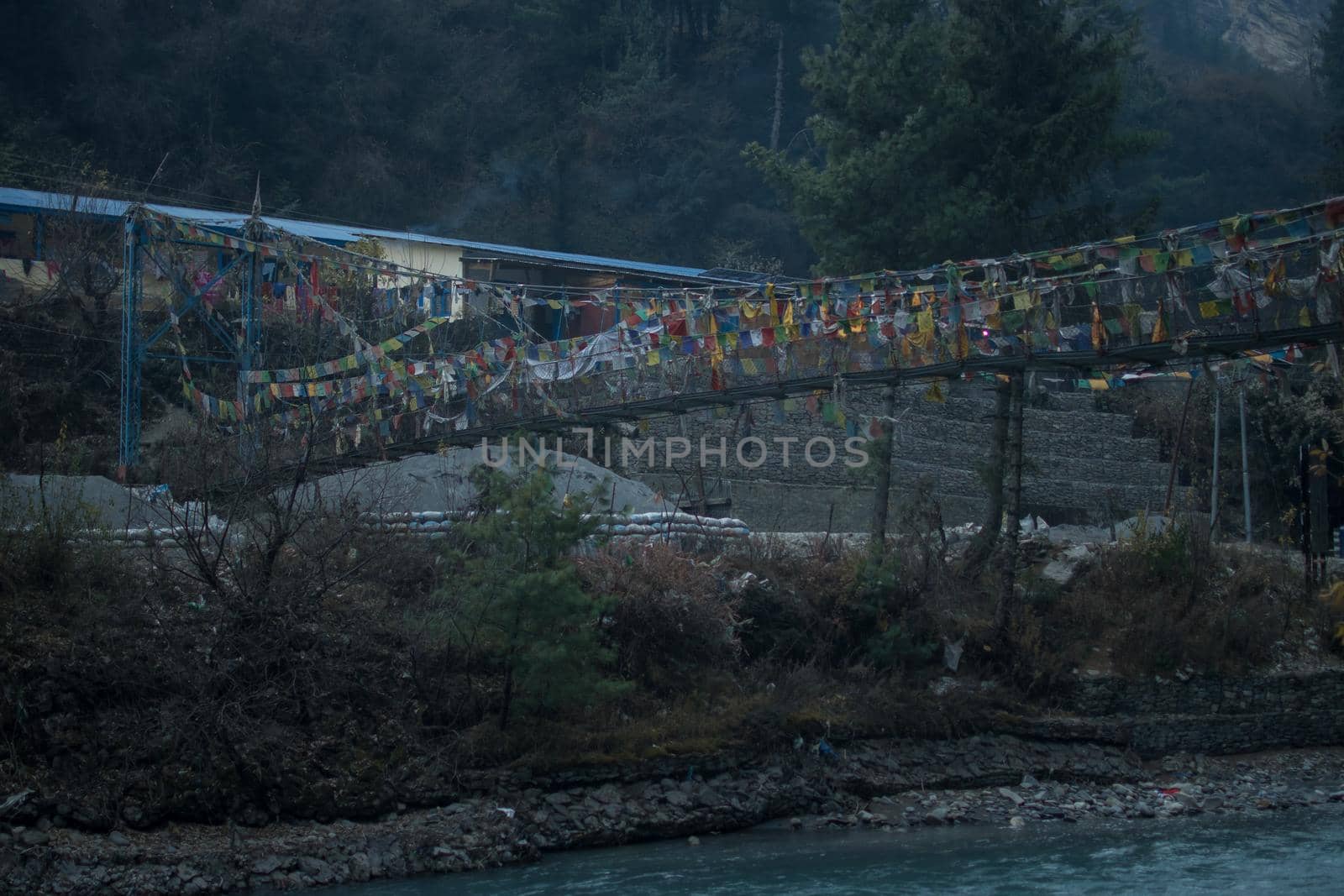 Chame suspension bridge colorful buddhist prayer flags over Marshyangdi river, Annapurna circuit, Nepal