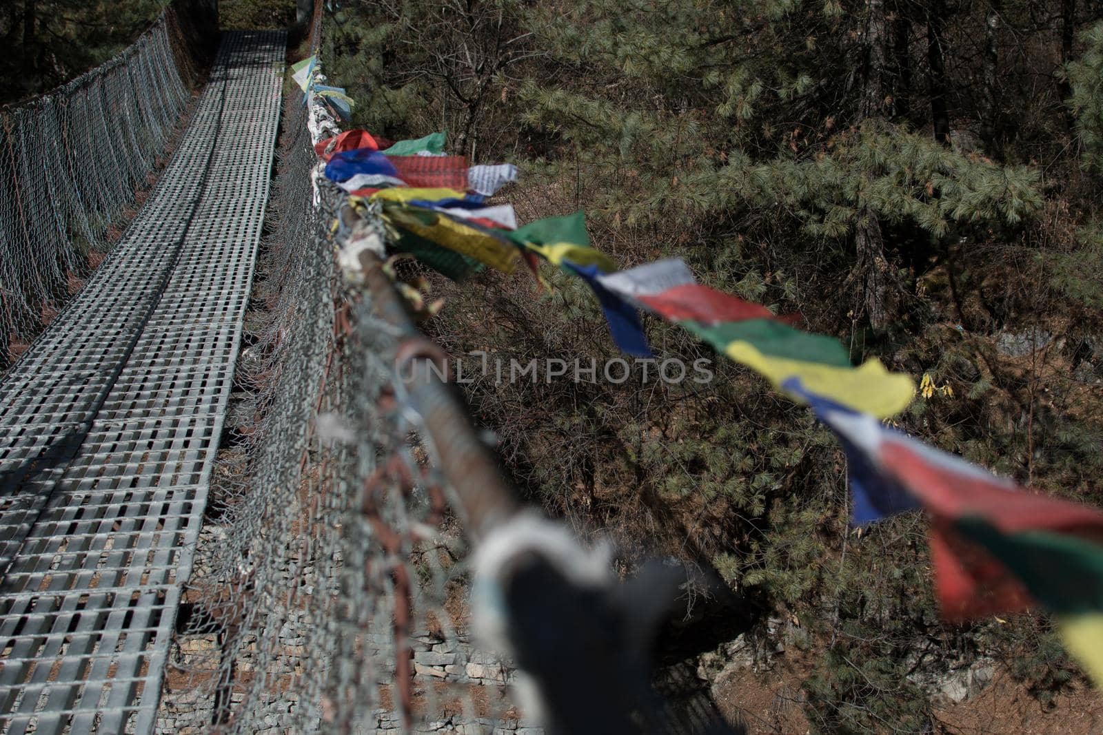 Trekking Annapurna circuit, suspension bridge with buddhist prayer flags over Marshyangdi river