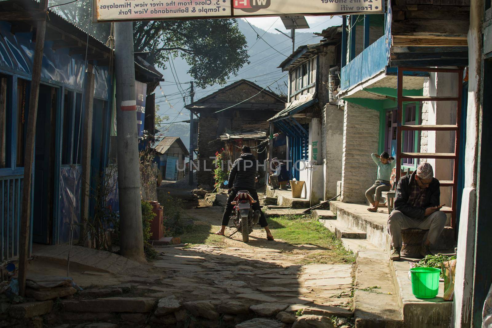 Traditional nepalese mountain village with a man on a motorcycle at Bahundanda, Annapurna circuit