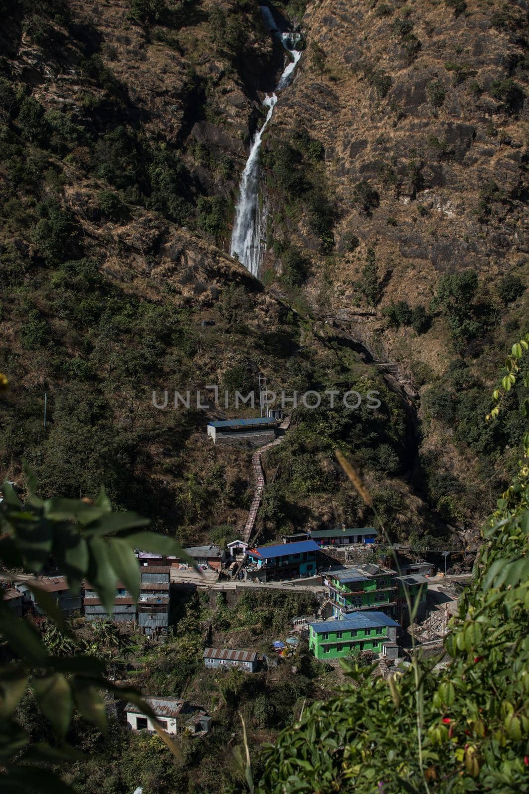 Waterfall flowing above a nepalese mountain village at Annapurna circuit