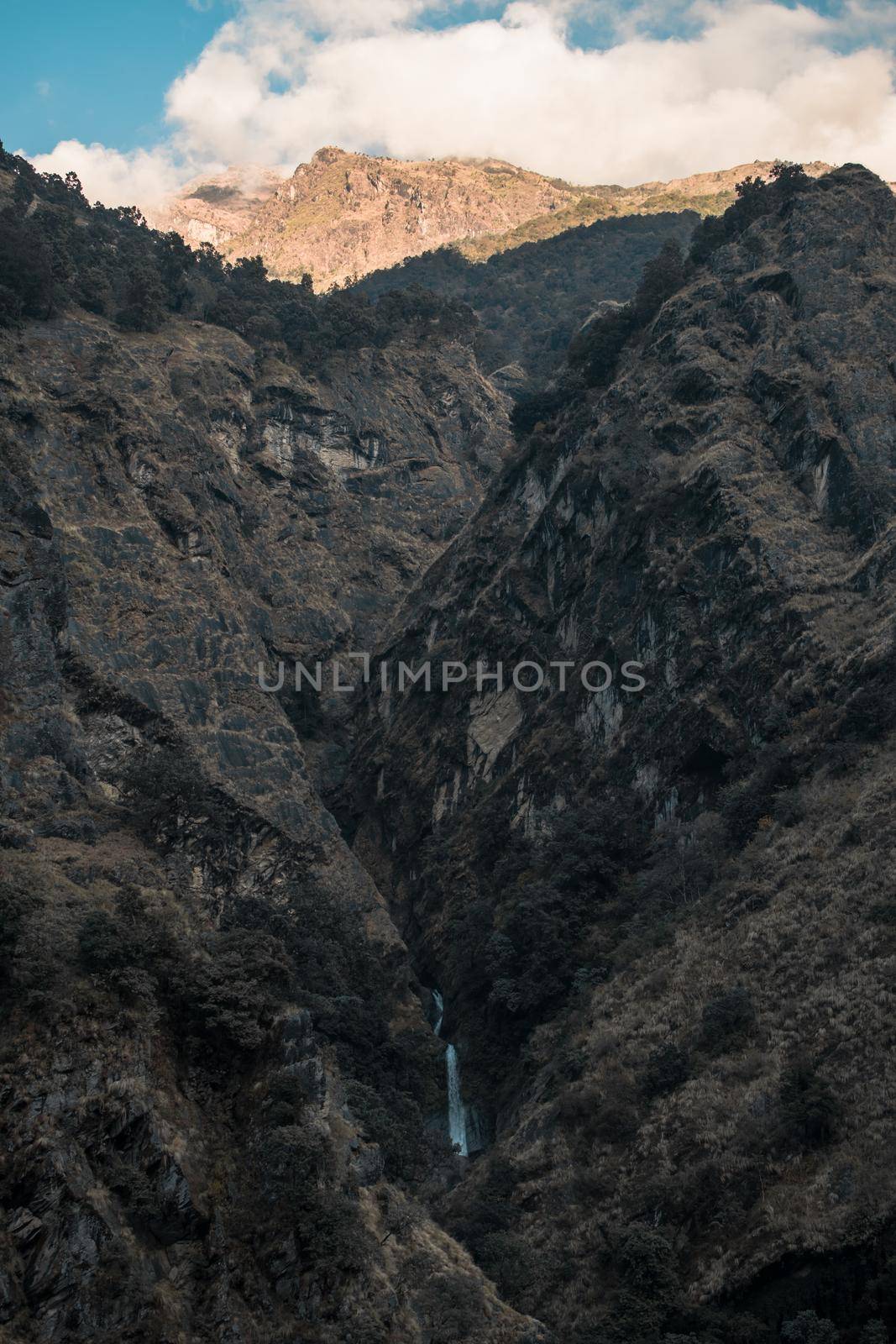 Small waterfall, huge mountains, shadows playing, Annapurna circuit, Nepal