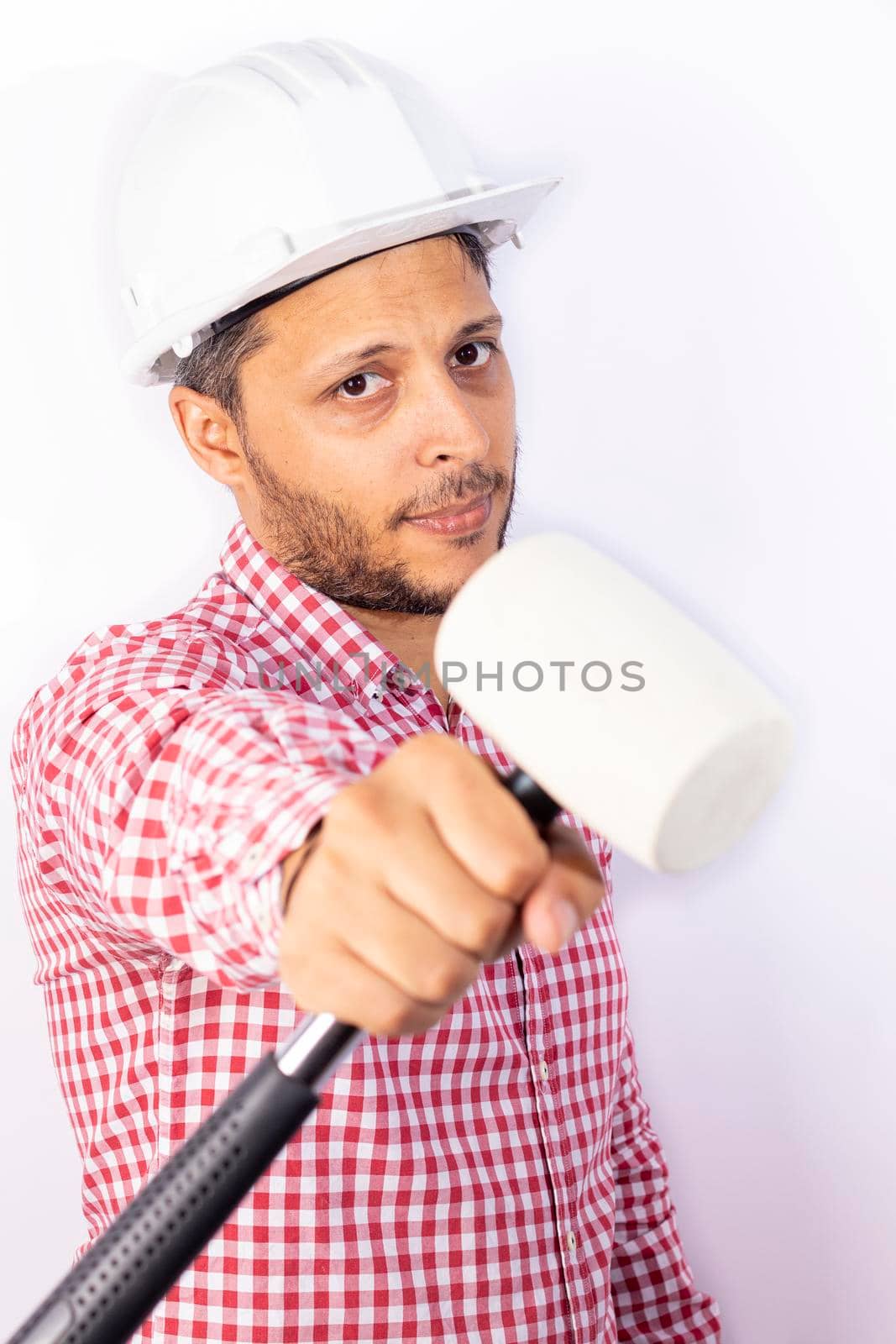 Handsome builder worker with white helmet showing his hammet