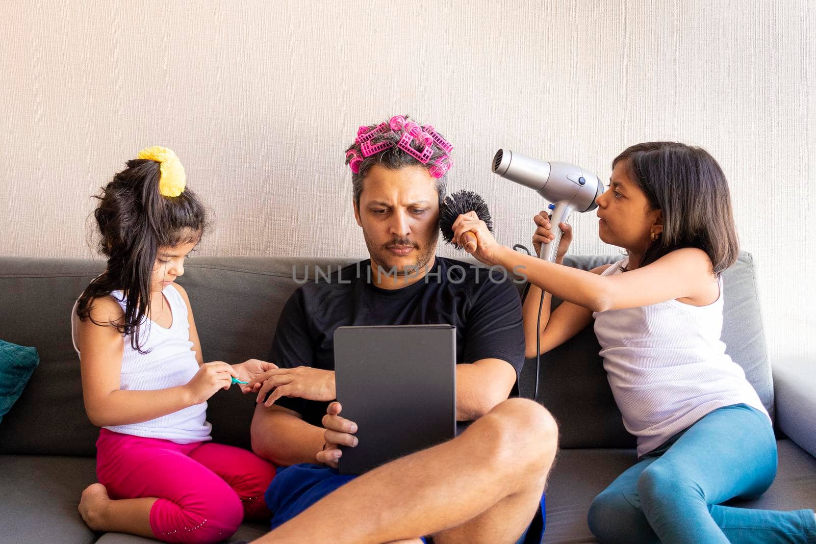 Pretty daughters are painting the nails and combing the hair of their handsome young father by eagg13