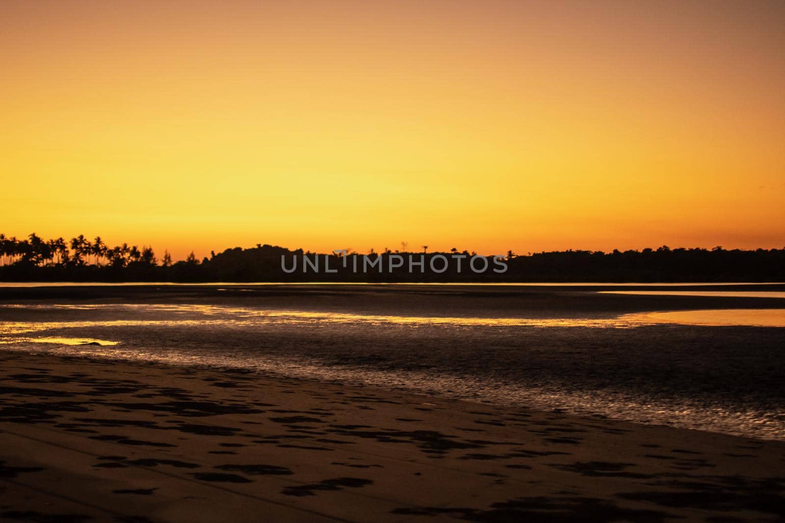 A sand beach during low tide and a bright orange sunset, peace and quiet, near Ngwesaung, Irrawaddy, western Myanmar