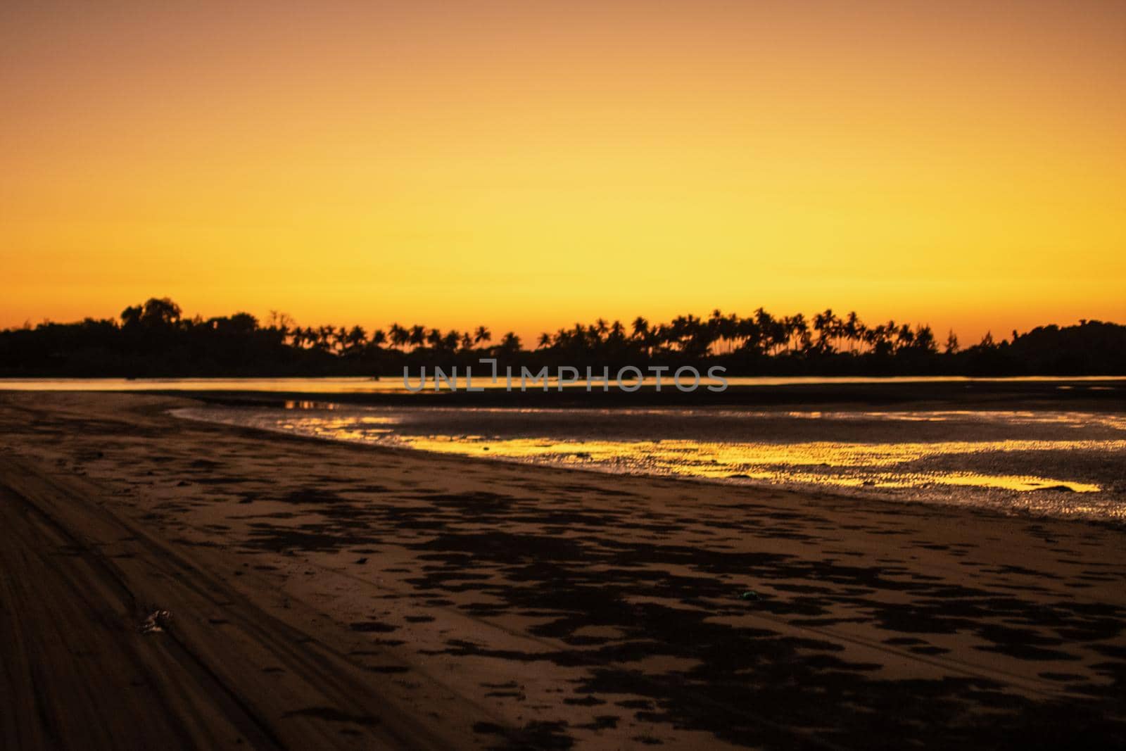 A sand beach during low tide and a bright orange sunset, peace and quiet, near Ngwesaung, Irrawaddy, western Myanmar