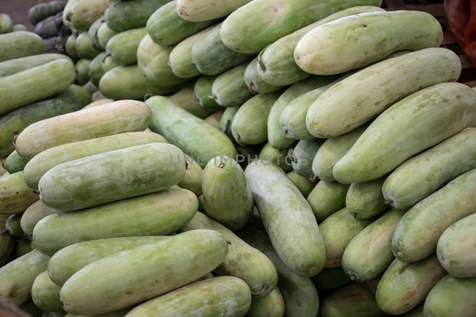 Fresh green tropical fruit, vegetables that looks like zucchini and squash at a local street market in Yangon, Myanmar