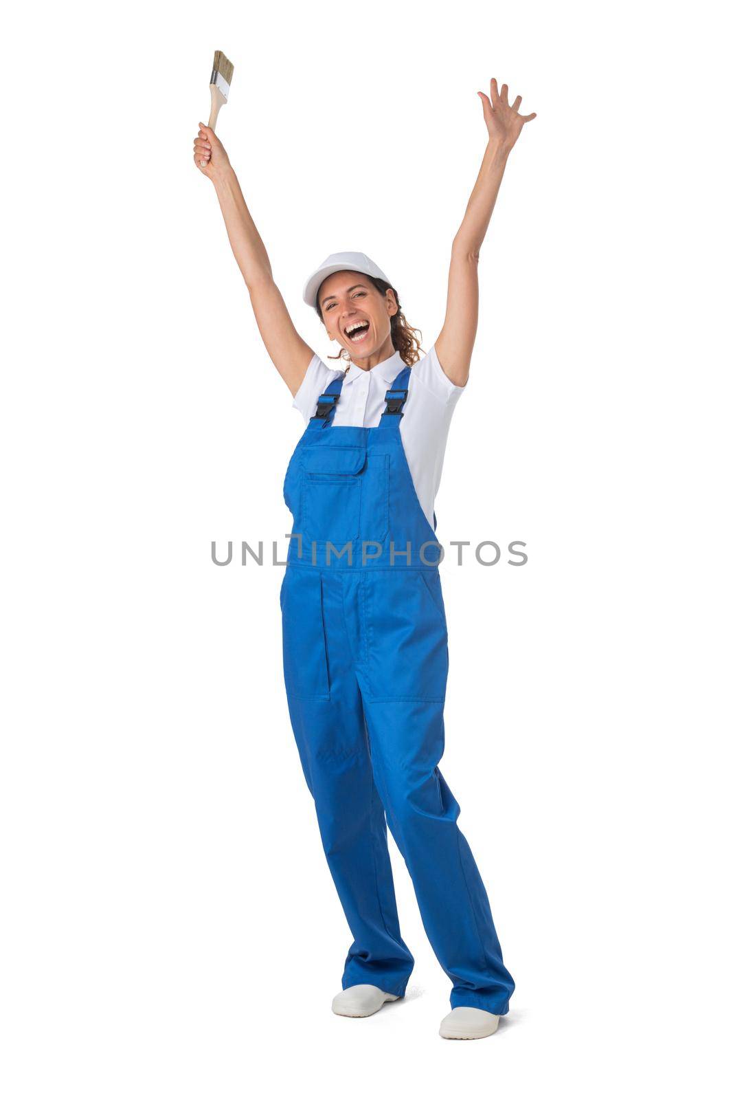 Female house painter with paint brush with raised arms isolated on white background full length studio portrait