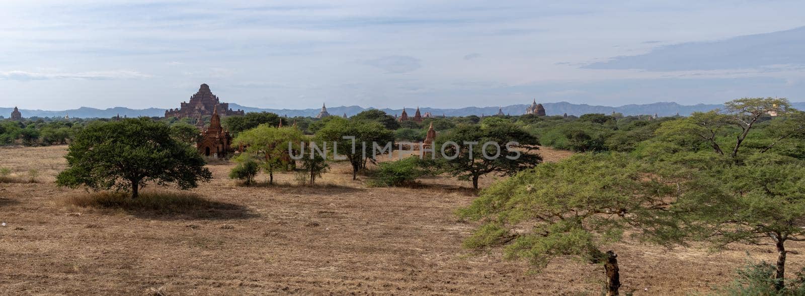 Several temples in the distance from an open dry grass field by arvidnorberg