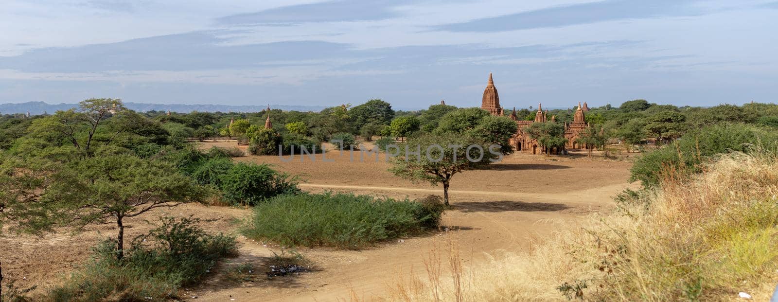 Several temples in the distance from an open dry grass field by arvidnorberg