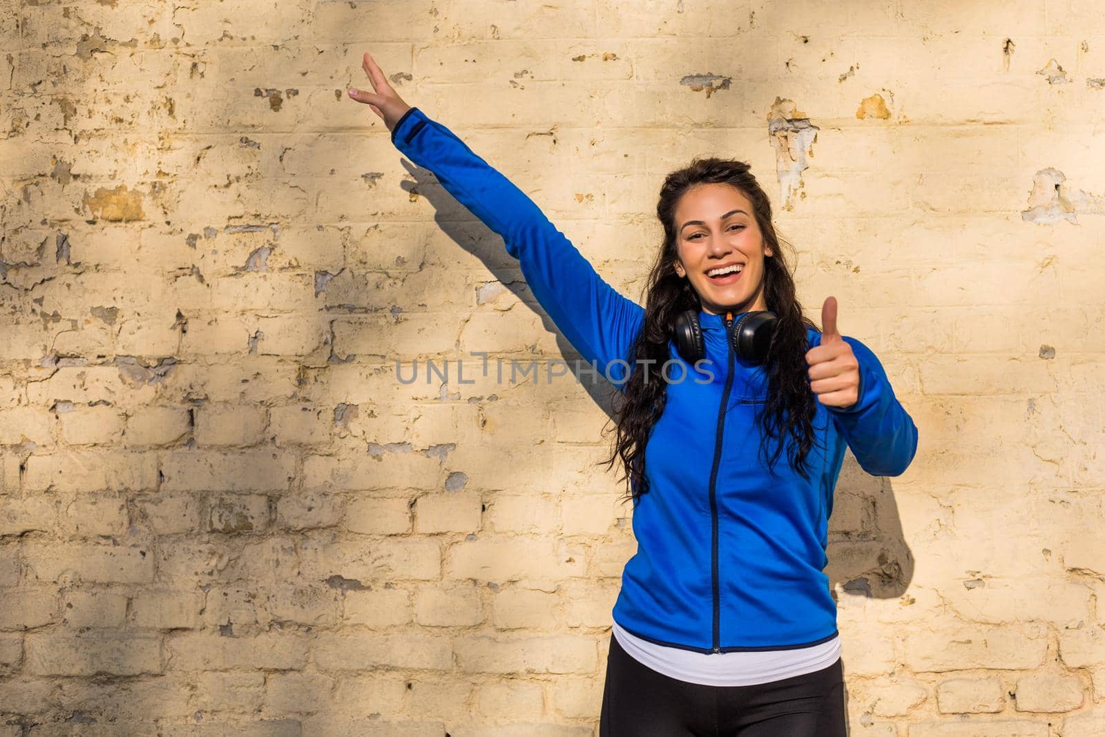Sporty woman showing thumb up by Bazdar