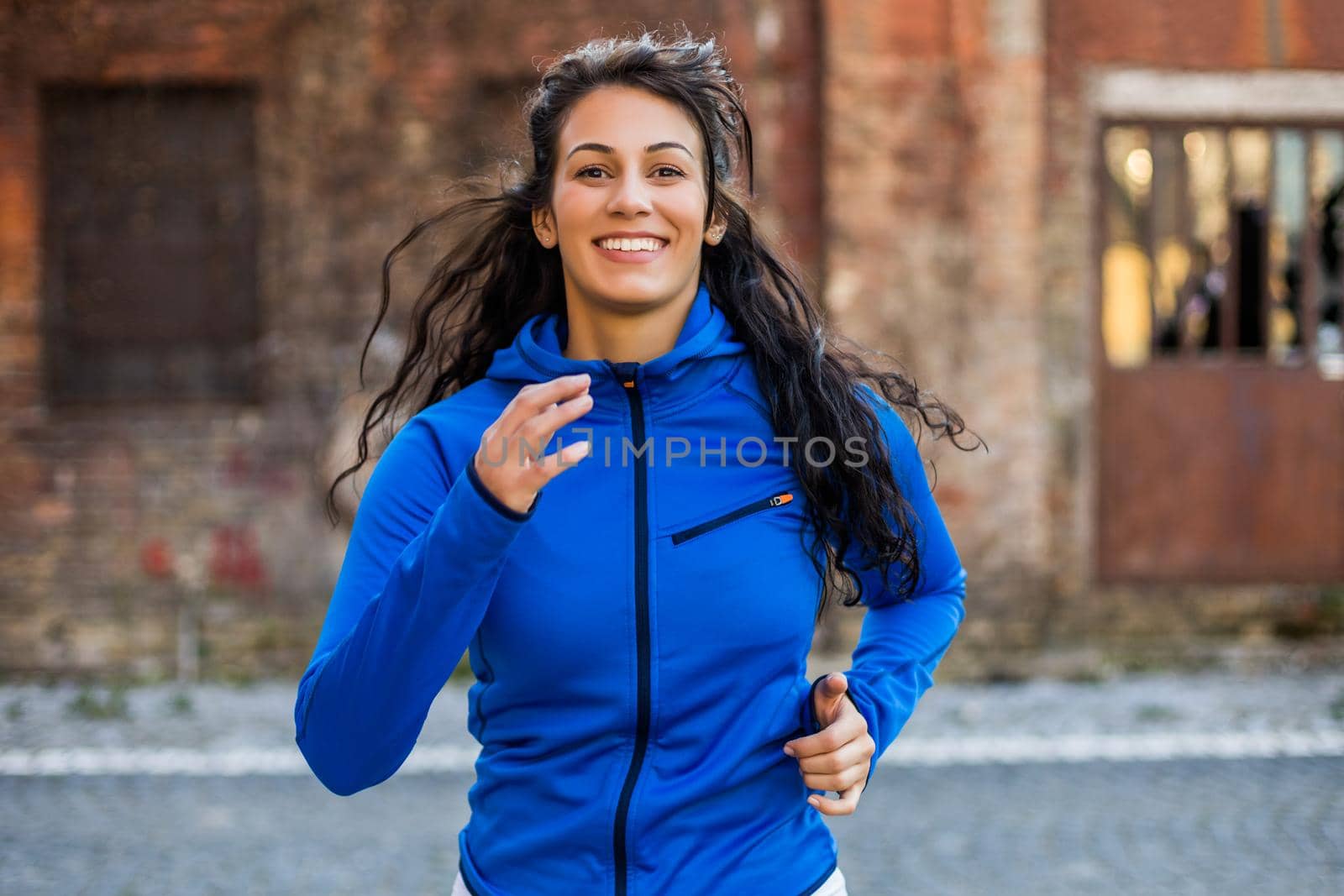 Beautiful young woman is jogging outdoor.