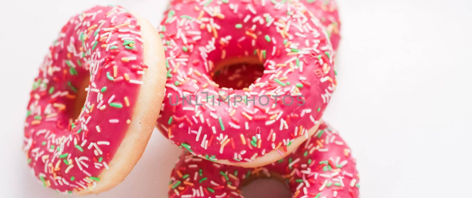 Bakery, branding and cafe concept - Frosted sprinkled donuts, sweet pastry dessert on marble table background, doughnuts as tasty snack, top view food brand flat lay for blog, menu or cookbook design