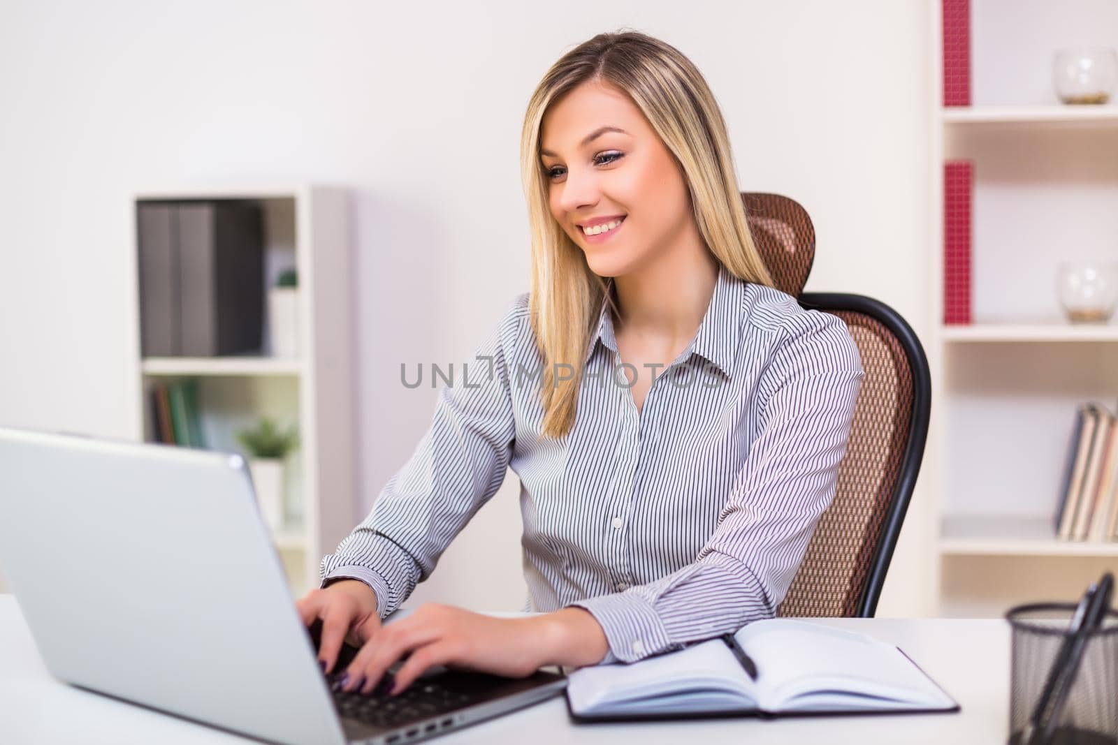 Businesswoman working at office by Bazdar