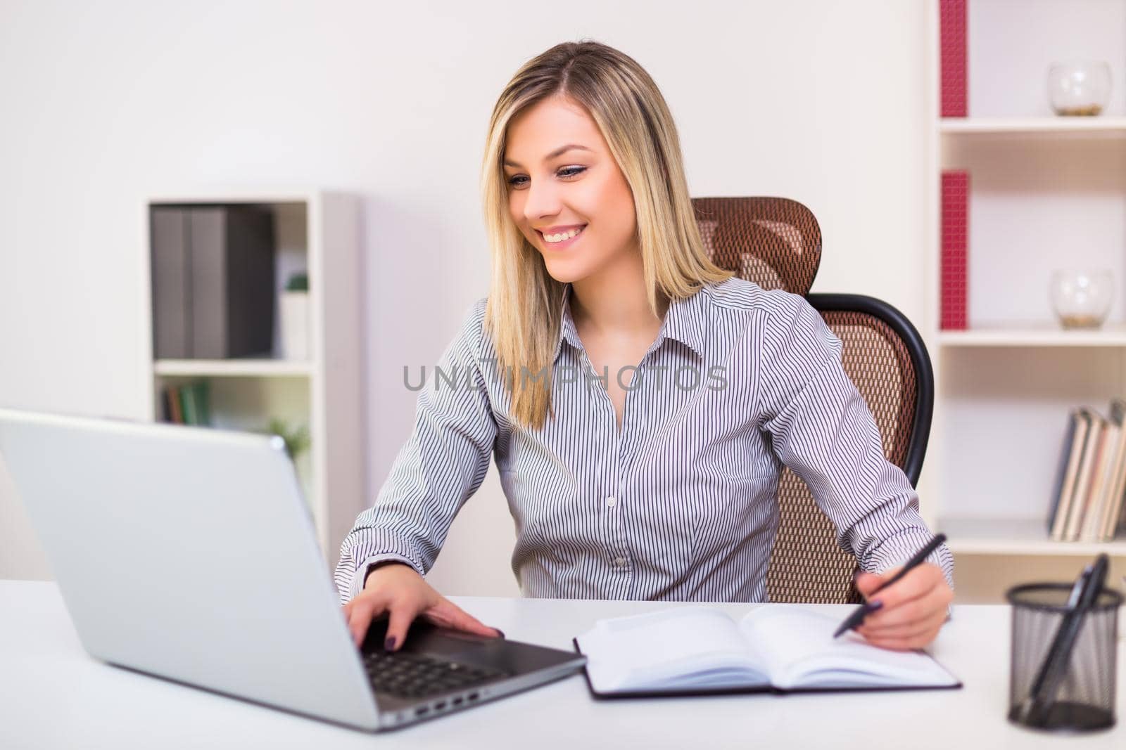 Businesswoman working at office by Bazdar