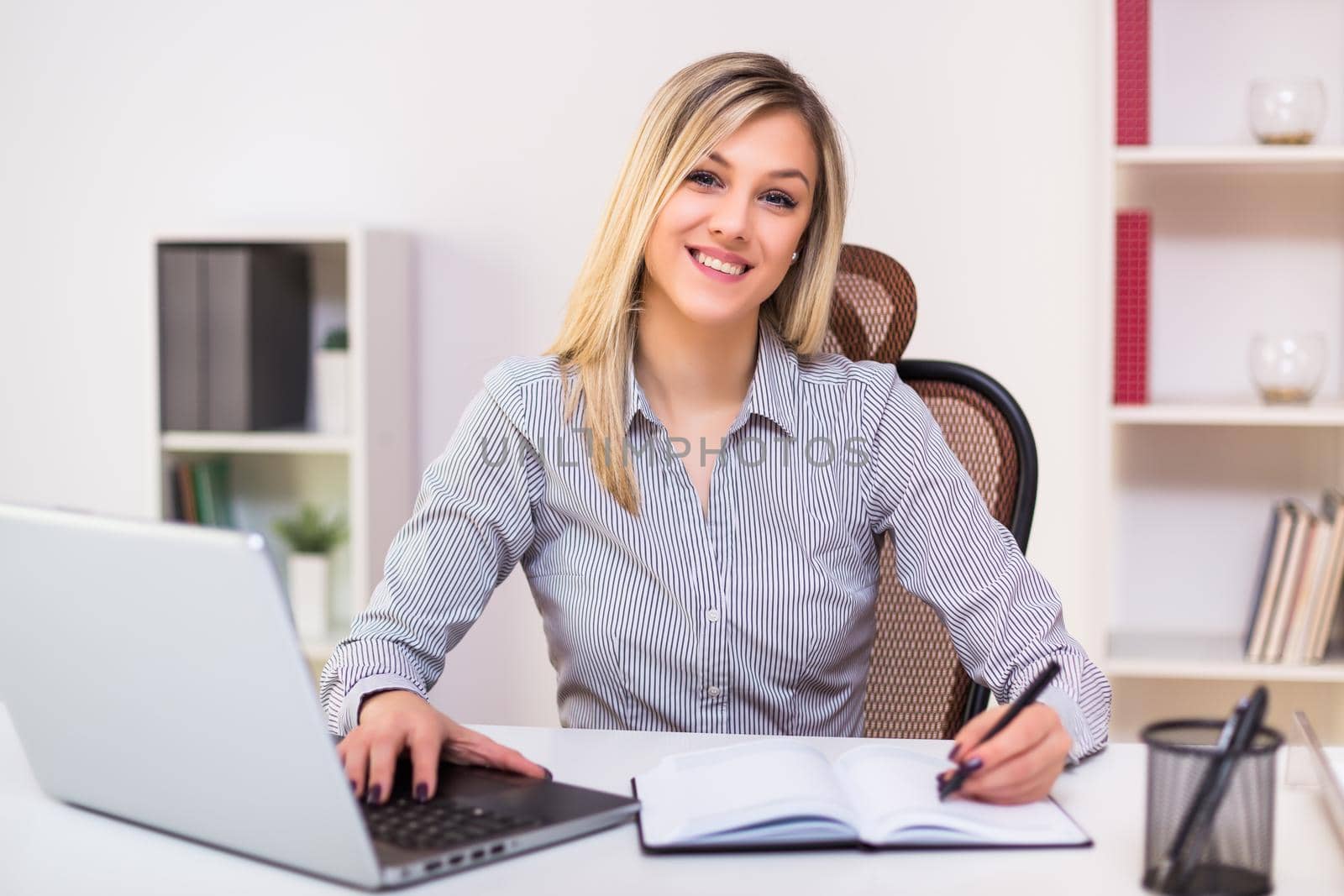 Businesswoman working at  office by Bazdar