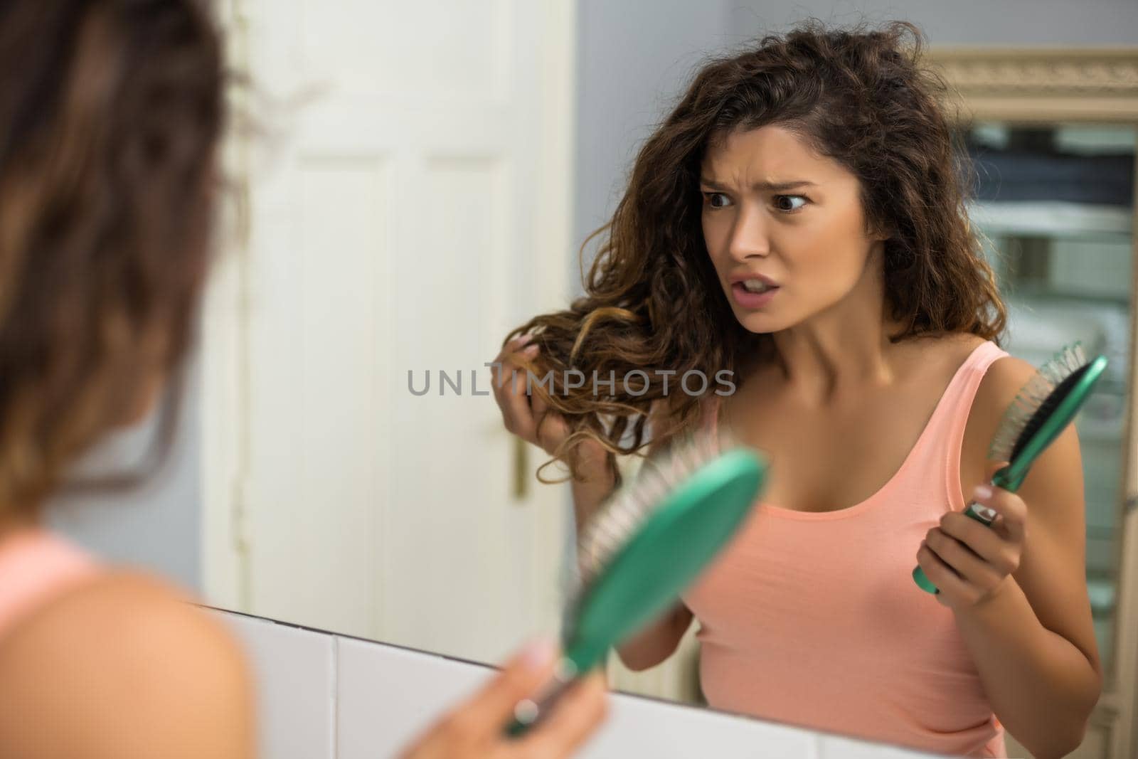 Beautiful woman is tired of brushing her long her every day.
