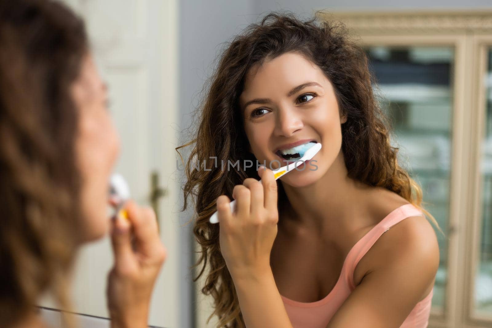 Beautiful woman brushing teeth in the bathroom.