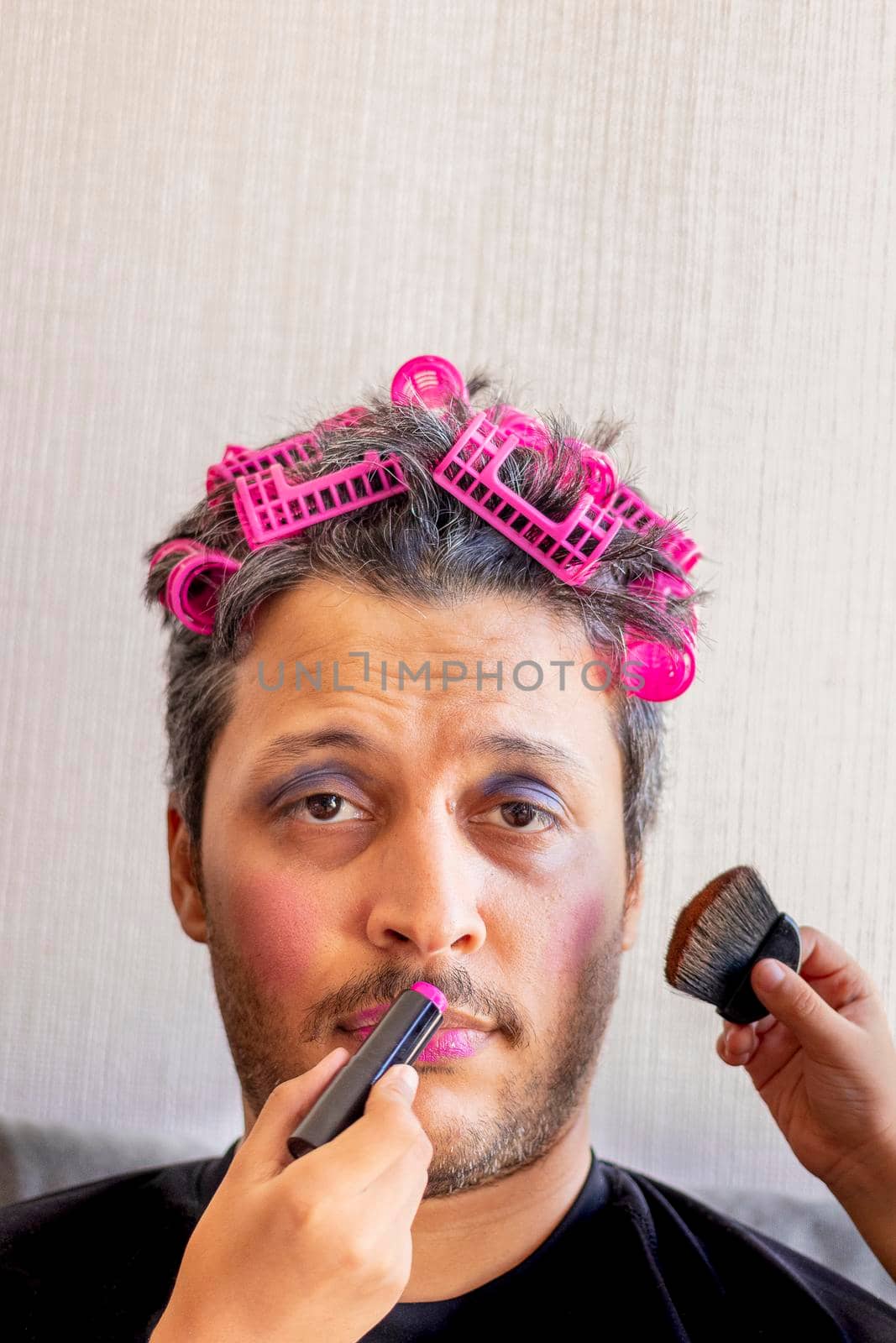 Handsome father is being makeup by the hands of his daughters