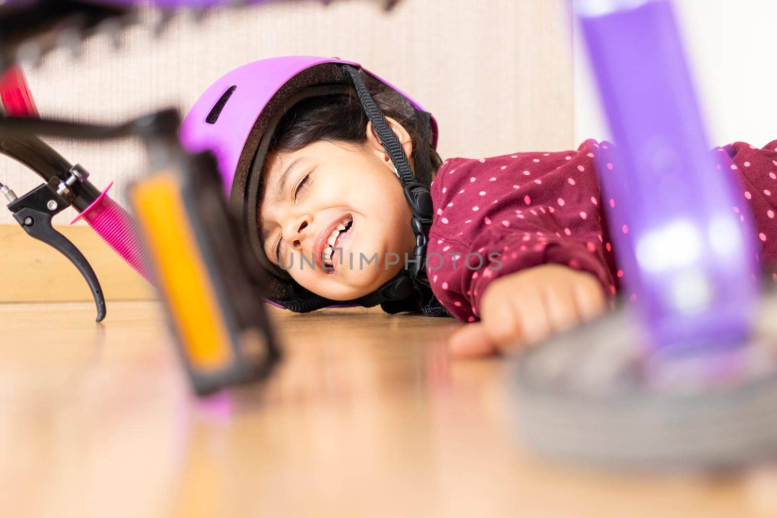 Sad little girl fell to the ground while playing with her bicycle in the house by eagg13