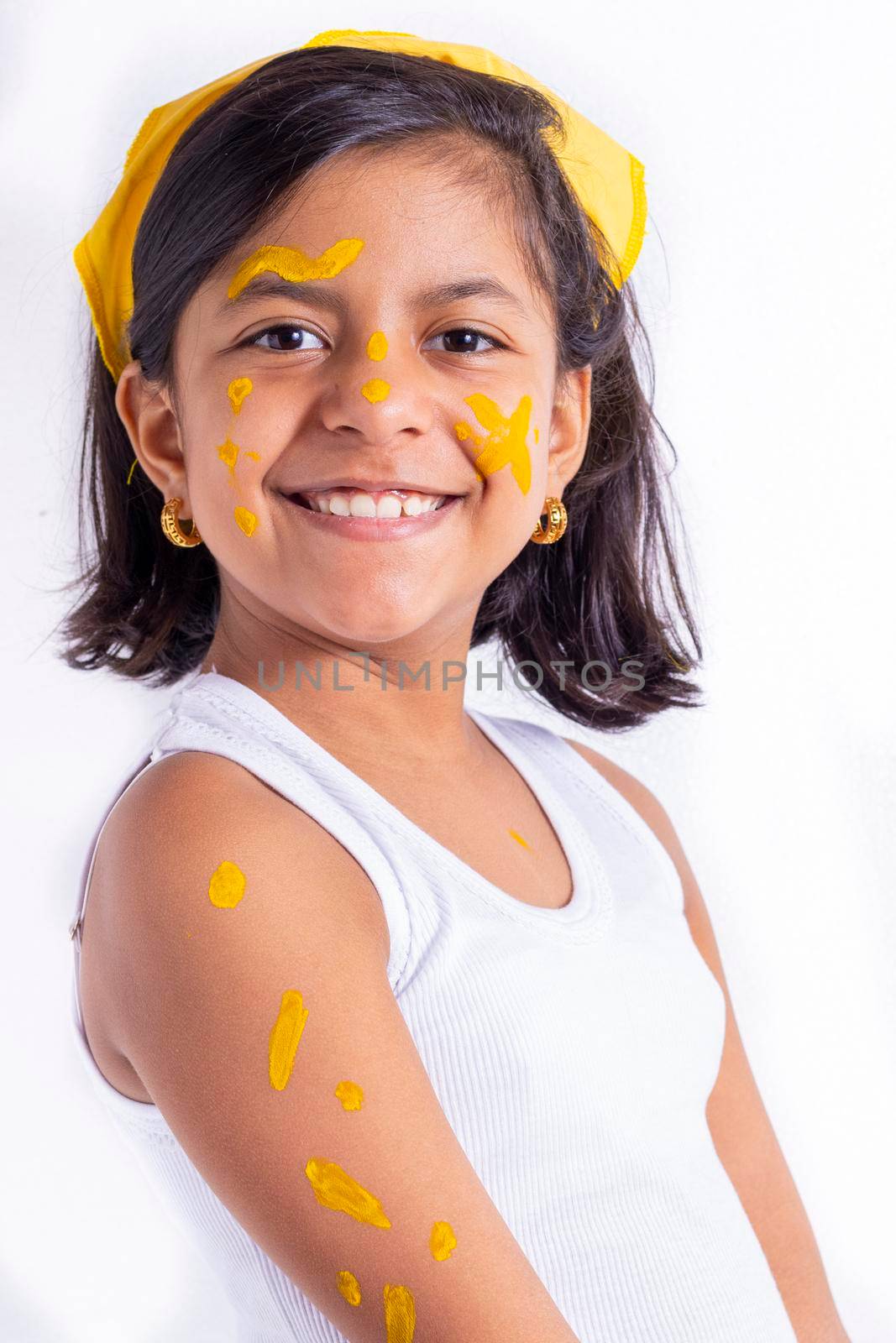 Happy little girl, with her face painted to celebrate the yellow day