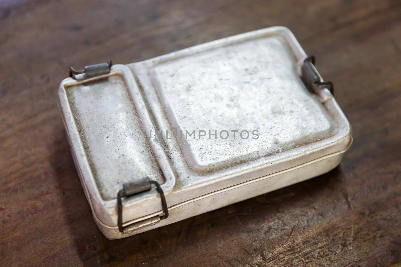 Closeup old and rusty aluminium lunch box on wooden table, old fashion vintage retro style