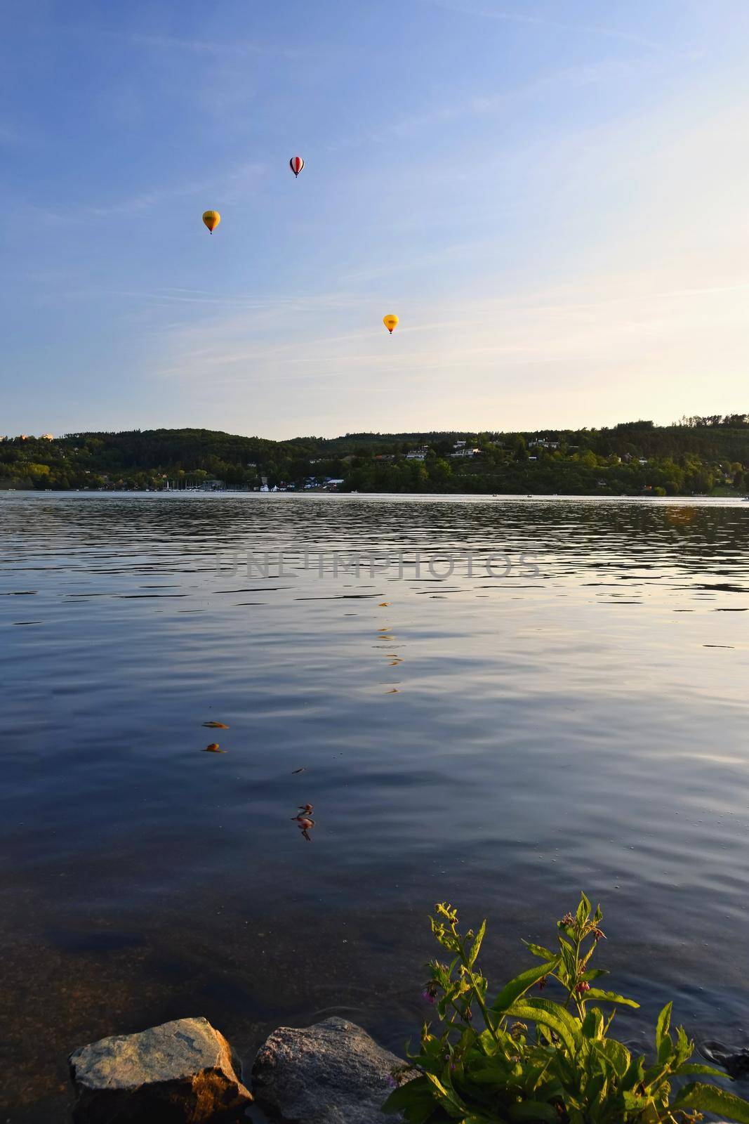 Colorful hot air balloon is flying at sunset. Brno Dam - Czech Republic. by Montypeter