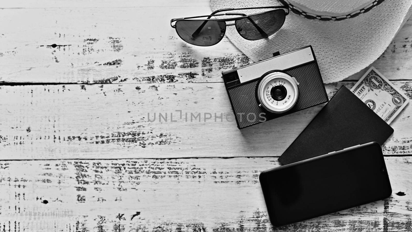 Items for summer vacation: a camera, passport,smartphone, money, hat, sunglasses. Wooden background, top view with Copy space. Beautiful summer concept for travel and vacation-holidays. by Montypeter