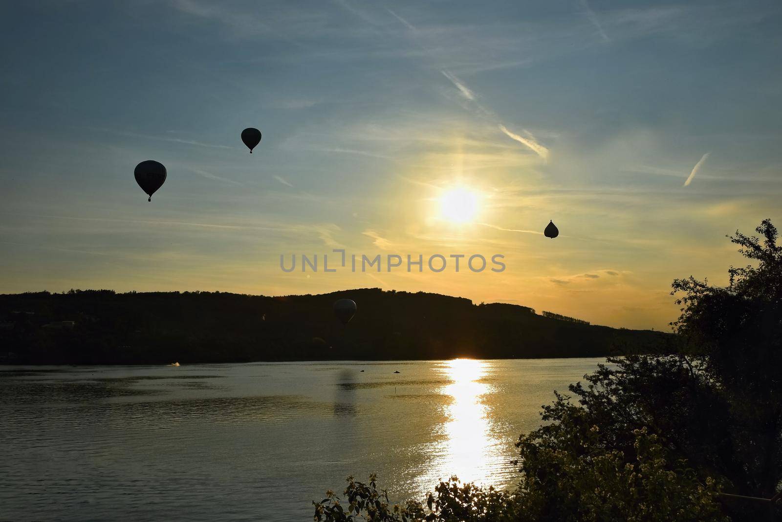 Colorful hot air balloon is flying at sunset. Brno Dam - Czech Republic. by Montypeter