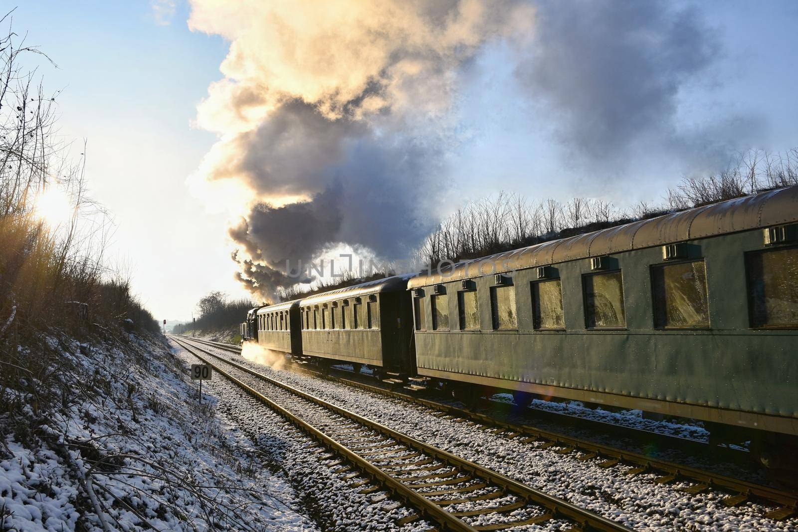 Beautiful old steam train with wagons running on rails at sunset. Excursions for children and parents on festive special days. Czech Republic Europe. by Montypeter