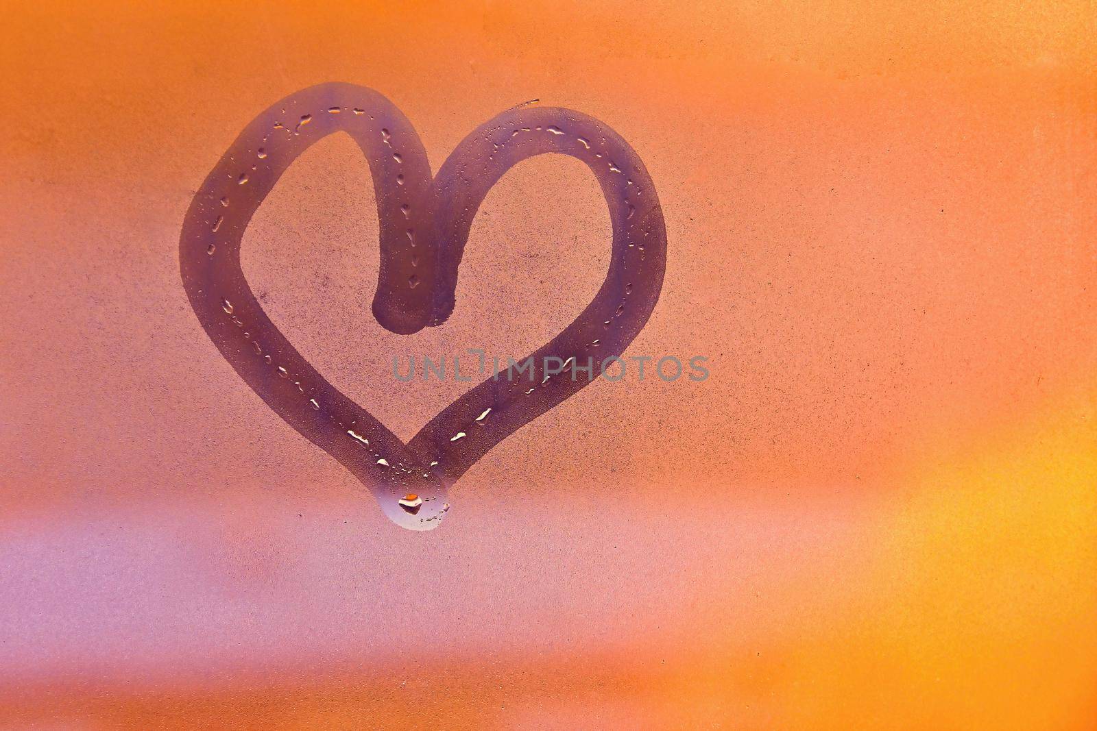 Heart painted with finger on foggy window