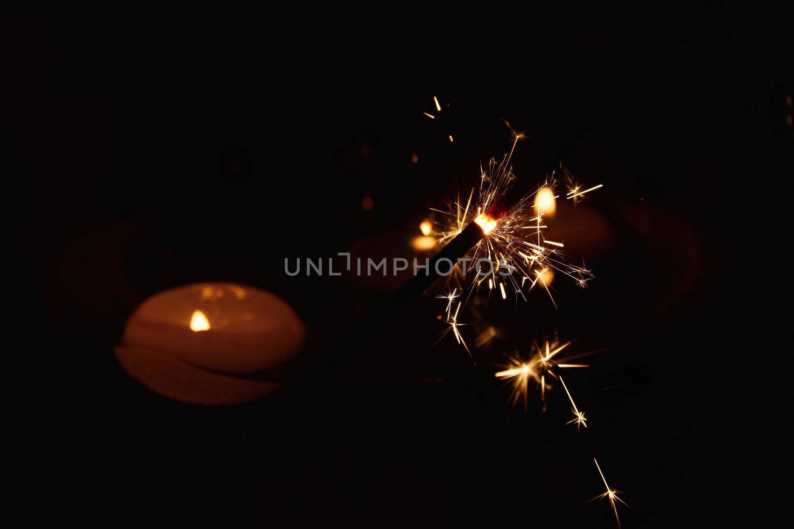 Sparkler Bokeh Colorful sparkler. Night background with candle. by Montypeter