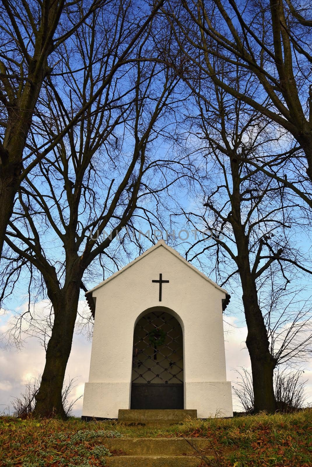 Beautiful little chapel with landscape and trees at sunset. Nebovidy - Czech Republic.