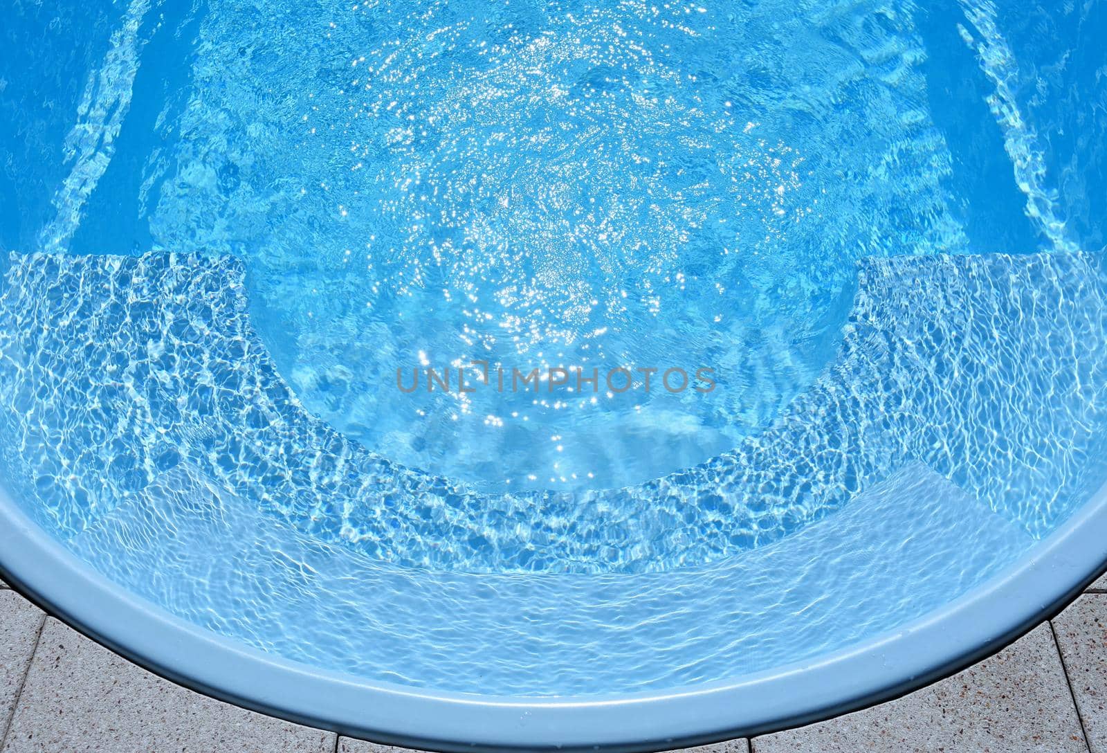 Ripple Water in swimming pool with sun reflection. Summer background for traveling and vacation. Holiday idyllic.