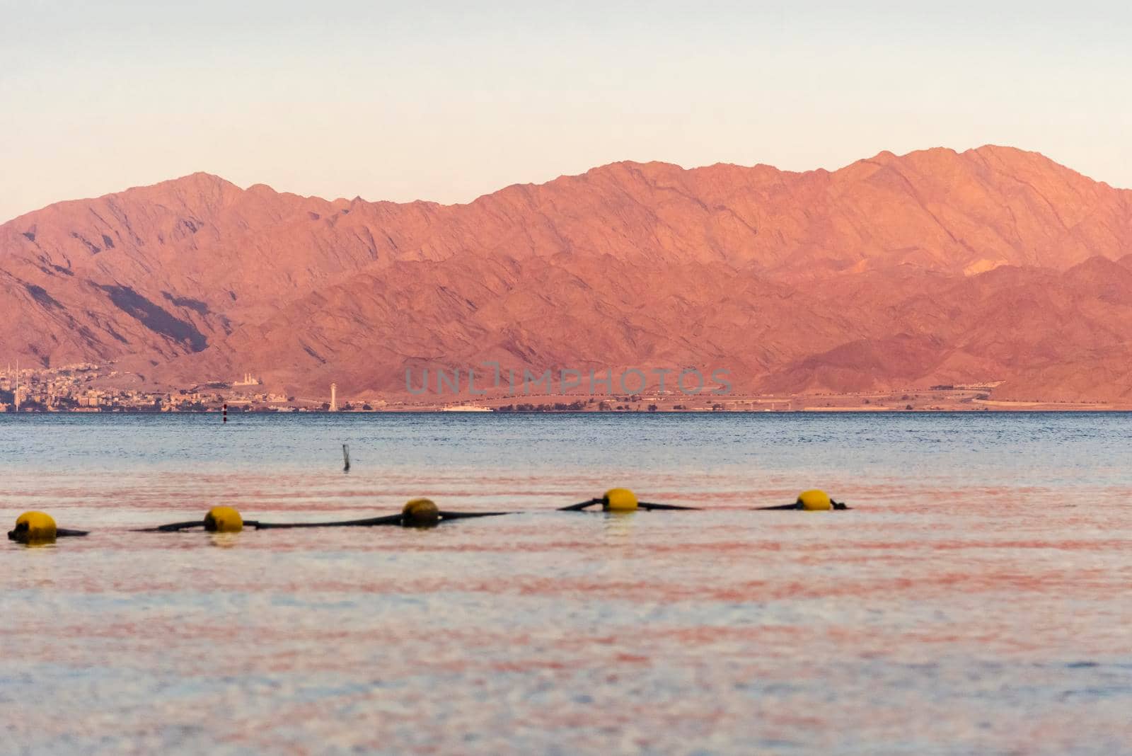 Sunset over the Red sea with pink orange mountains on the background. Eilat, Aqaba, Israel, Jordan . High quality photo