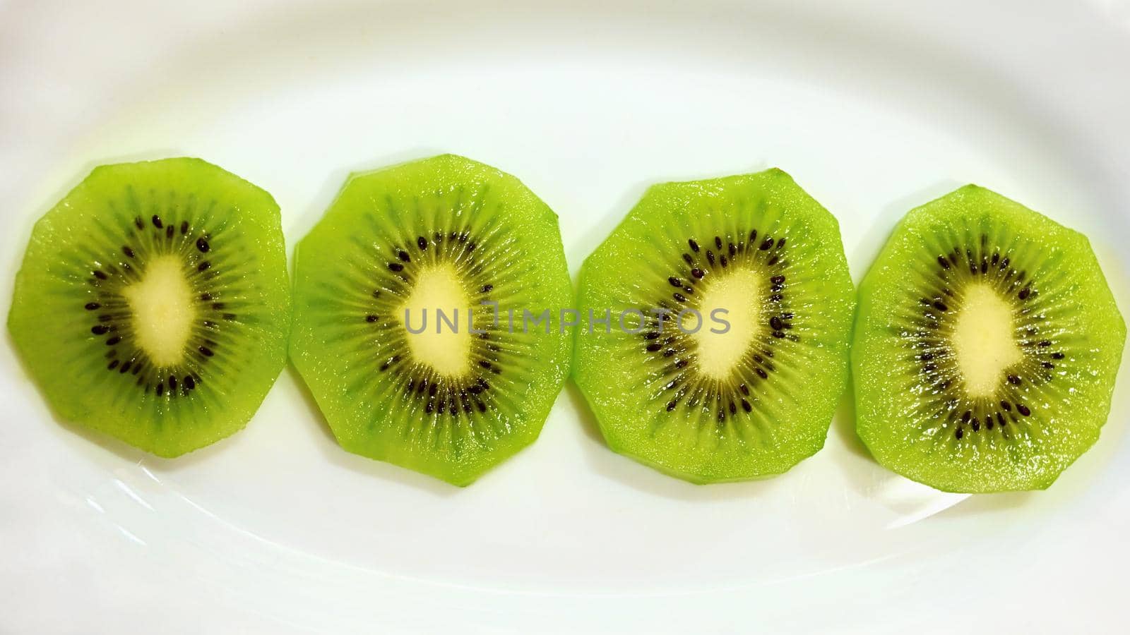 Kiwi on a plate. Close-up macro photo of healthy green tropical fruit by Montypeter