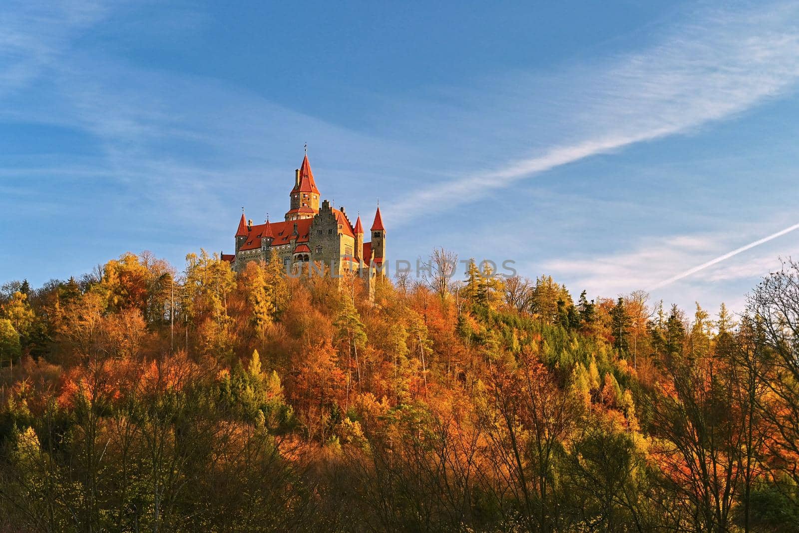 Beautiful old romantic Bouzov castle at sunset with autumn landscape. by Montypeter