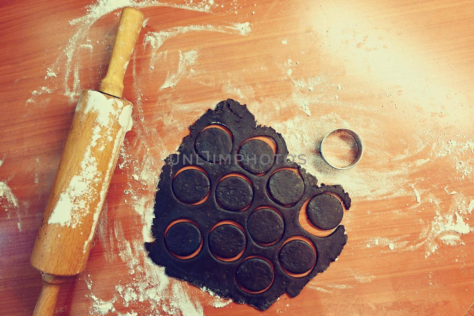 Baking Christmas cookies. On the table, flour, roller and dough. by Montypeter