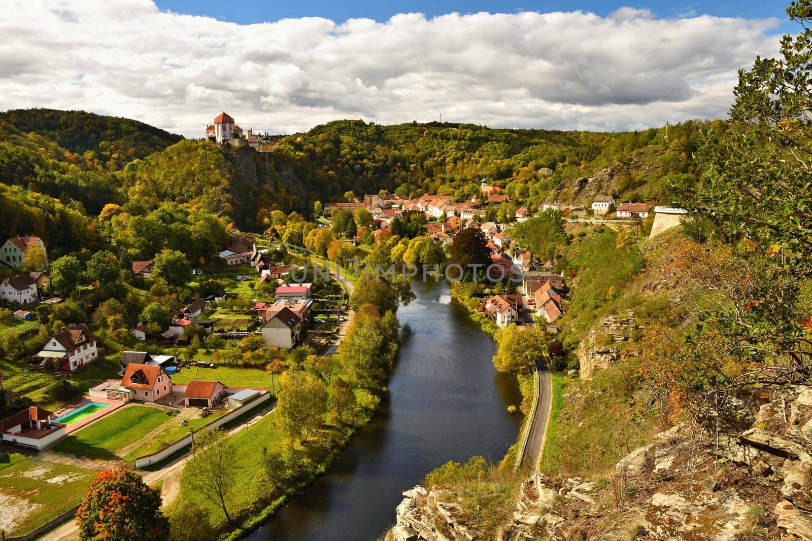 Beautiful autumn landscape with river, castle and blue sky with clouds and sun. Vranov nad Dyji (Vranov above Thaya) chateau, river Thaya, Czech Republic.