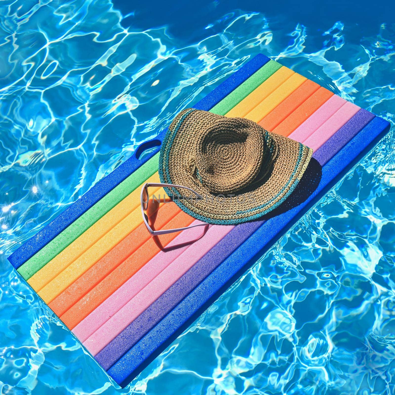 Sunglasses, lilo and hat on the water in hot sunny day. Summer background for traveling and vacation. Holiday idyllic. by Montypeter