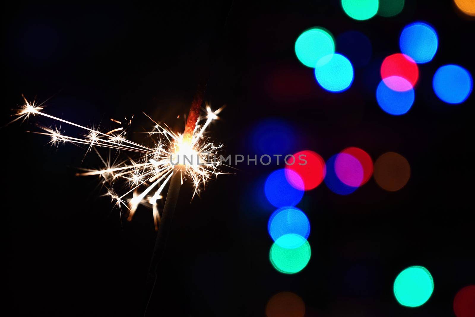 Concept for Christmas and Happy New Year.
Burning sparkler with beautiful color background.
